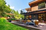 Experience seamless indoor-outdoor living with this stunning modern home featuring a spacious wooden deck perfect for entertaining.