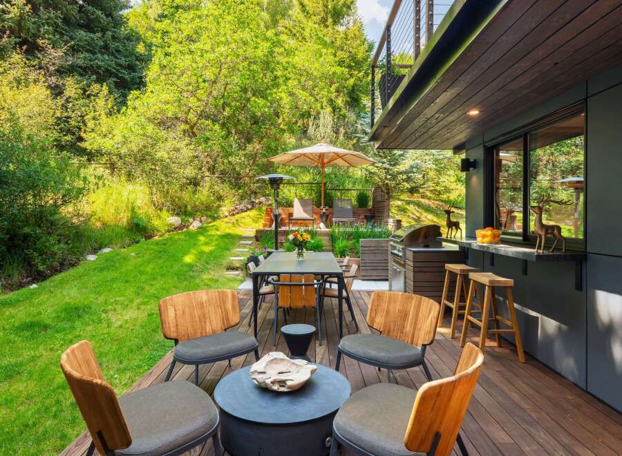 Enjoy outdoor living at its finest on this expansive deck, complete with a dining area, grill station, and bar seating.