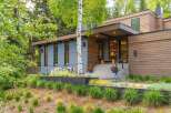 Experience modern luxury in this stunning home, featuring a striking facade of wood and gray paneling.