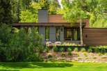 Experience modern luxury in this stunning home, featuring a sleek gray facade complemented by warm wood accents.
