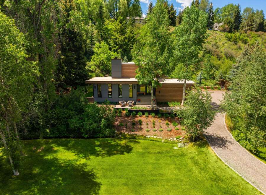 Nestled amidst lush greenery, this modern home offers a serene retreat with its striking architectural design.