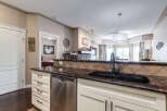 This stunning kitchen features a beautiful granite countertop with a double sink and a dark bronze faucet.