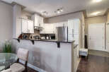 Discover this stunning kitchen featuring sleek white cabinetry, a granite countertop, and a stainless steel refrigerator.