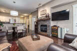 Experience comfort and style in this inviting living space, featuring a cozy stone fireplace and a large ottoman perfect for relaxation.