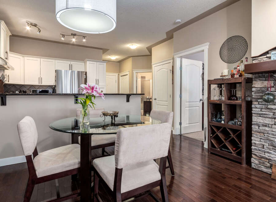 This inviting dining area features a sleek glass-top dining table with plush chairs, perfect for intimate meals.