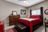 Experience comfort and style in this inviting bedroom, featuring a plush red comforter and a cozy white throw.