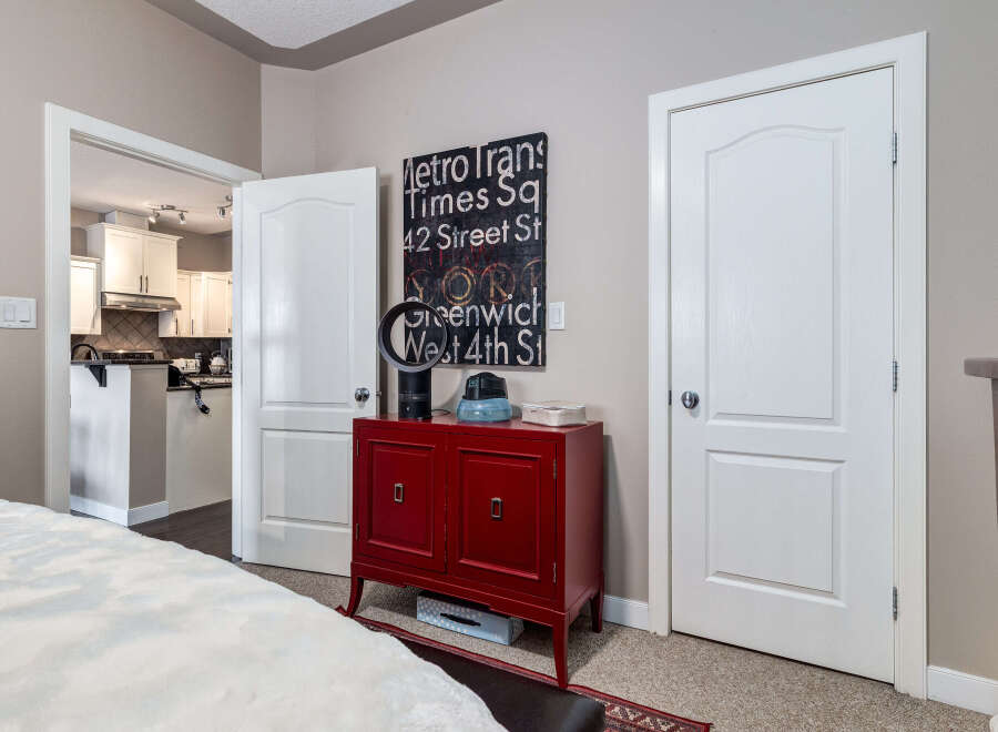 Discover a seamless flow between living spaces with this inviting layout, featuring a bright and modern kitchen visible through an open doorway.