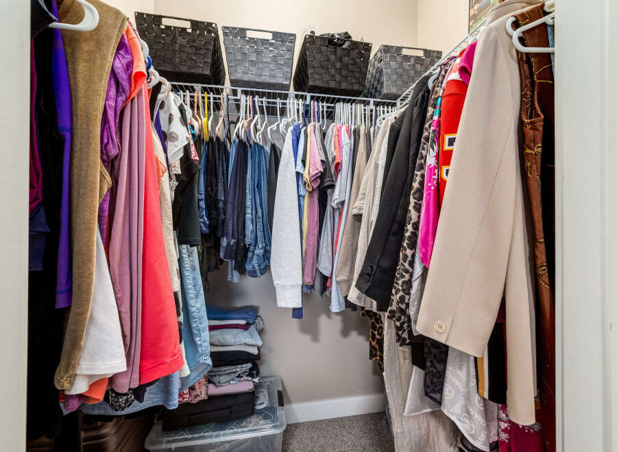 Maximize your storage with this spacious walk-in closet, featuring ample hanging space and organized shelving.