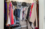 Maximize your storage with this spacious walk-in closet, featuring ample hanging space and organized shelving.
