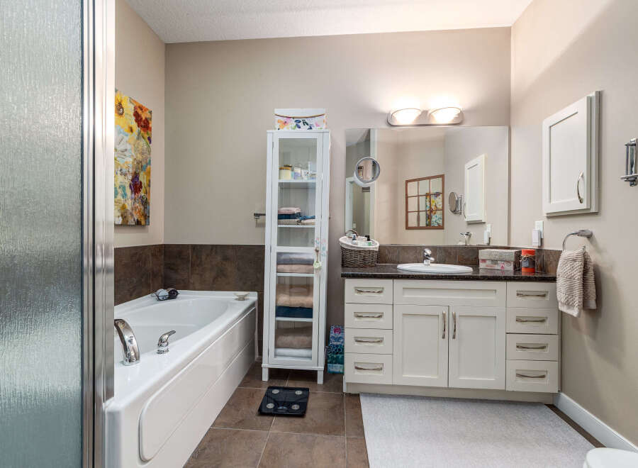 Indulge in relaxation in this spacious bathroom, featuring a deep soaking tub perfect for unwinding after a long day.