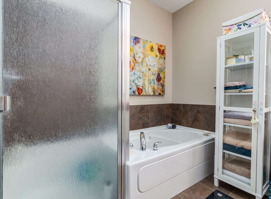 Indulge in relaxation in this luxurious bathroom featuring a spacious corner bathtub, perfect for unwinding after a long day.