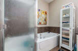 Indulge in relaxation in this luxurious bathroom featuring a spacious corner bathtub, perfect for unwinding after a long day.