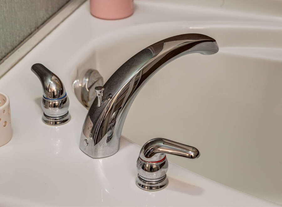 Experience luxury and comfort in this stunning bathroom, featuring a sleek, modern bathtub faucet.