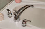 Experience luxury and comfort in this stunning bathroom, featuring a sleek, modern bathtub faucet.
