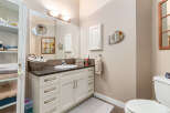 This bright and airy bathroom features a spacious vanity with ample storage and a sleek granite countertop.