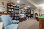 This inviting recreational space features a well-stocked lending library with a diverse collection of books and puzzles, perfect for unwinding.