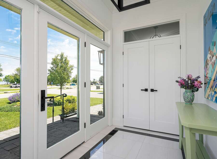 Step into this inviting entryway featuring elegant double doors that open to a bright and airy space.