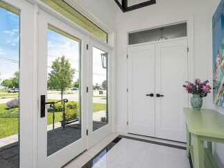 Step into this inviting entryway featuring elegant double doors that open to a bright and airy space.