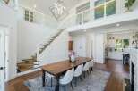 Experience modern luxury in this stunning home featuring a grand staircase with glass railings and a striking geometric chandelier.