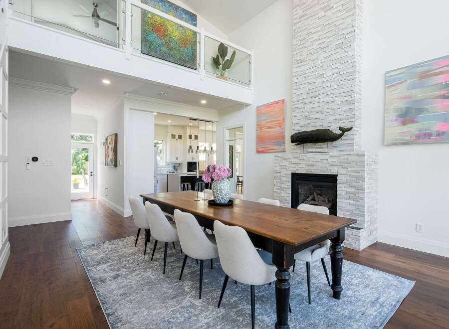 Experience elegant dining in this spacious room, featuring a rustic wooden table surrounded by comfortable upholstered chairs.