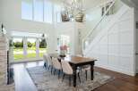 Experience luxurious modern living in this stunning dining room, featuring a grand chandelier and expansive windows that flood the space with natural light.