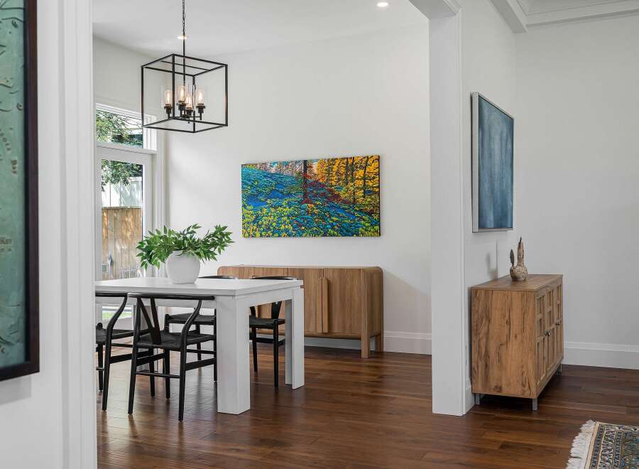 Experience elegant dining in this beautifully appointed space, featuring a modern white table with sleek black chairs perfect for intimate gatherings.