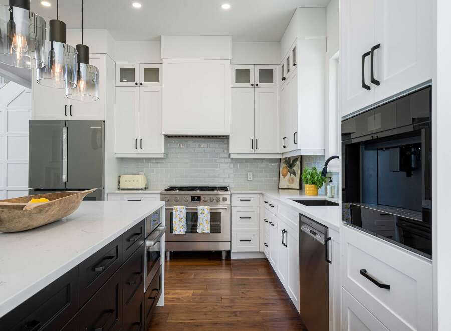 Experience culinary excellence in this stunning modern kitchen, featuring sleek white cabinetry, a professional-grade stainless steel range, and a sophisticated built-in coffee maker.