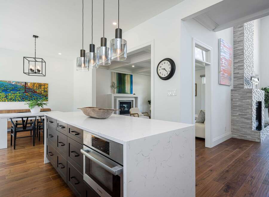 Experience modern luxury in this stunning kitchen, featuring a sleek island with a built-in oven and ample storage.