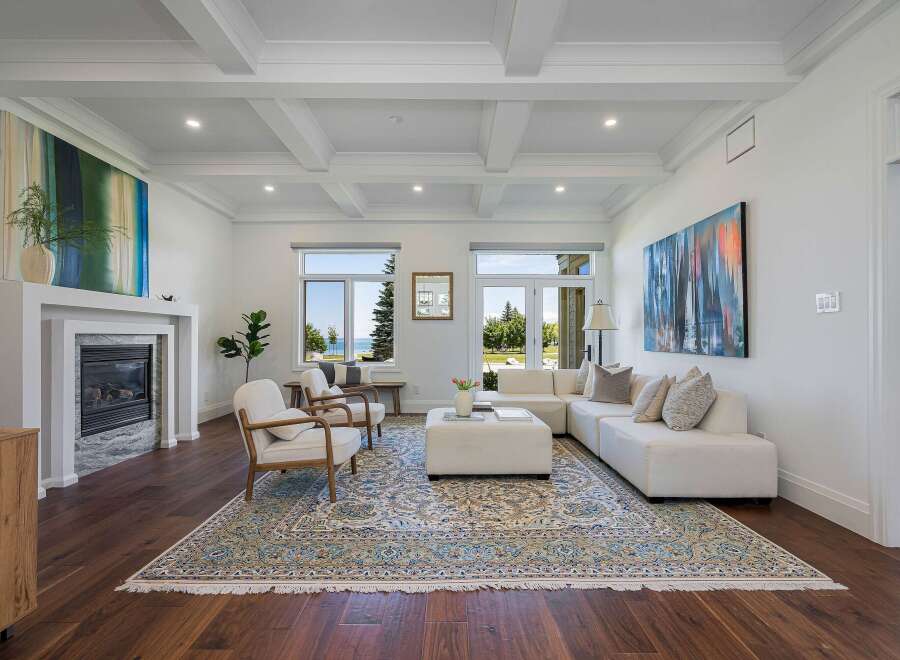 Experience luxury living in this stunning living room, featuring a modern fireplace and a coffered ceiling.
