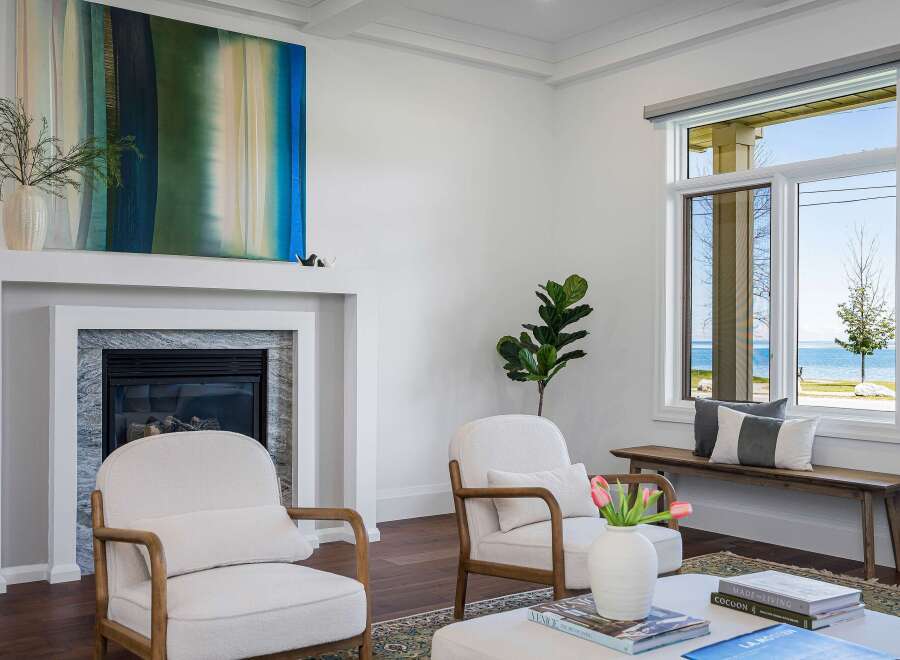 Experience breathtaking lake views from this stunning living room, featuring a modern fireplace and comfortable seating.