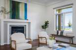 Experience breathtaking lake views from this stunning living room, featuring a modern fireplace and comfortable seating.