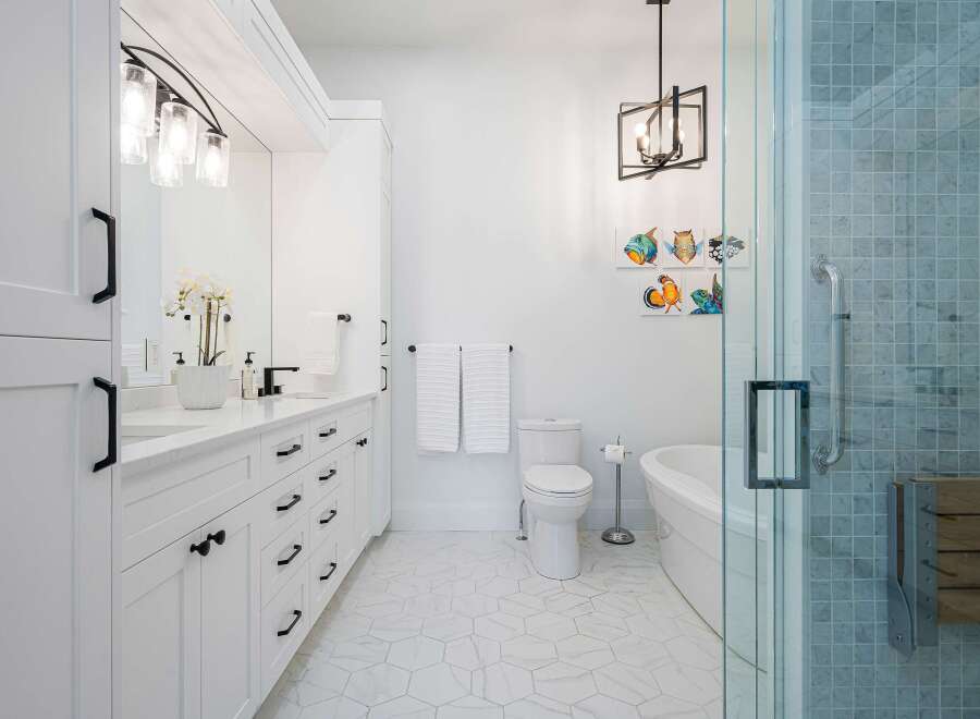 Experience modern luxury in this stunning bathroom featuring a sleek white vanity with ample storage and a freestanding bathtub.
