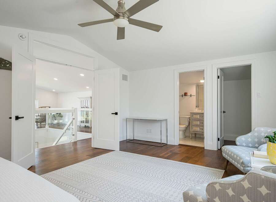 Step into this beautifully appointed bedroom, featuring a modern ceiling fan and a stylish rug.