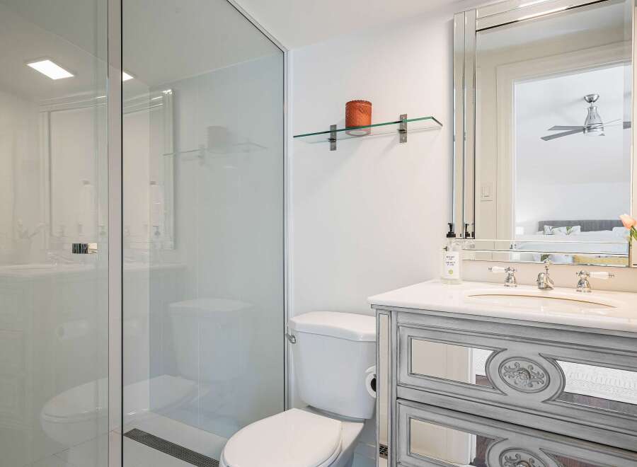 Experience modern luxury in this stunning bathroom, featuring a sleek glass-enclosed shower and a stylish vanity with mirrored accents.