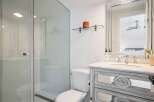 Experience modern luxury in this stunning bathroom, featuring a sleek glass-enclosed shower and a stylish vanity with mirrored accents.