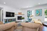 This cozy living room features a modern fireplace with a rustic wood mantel, perfect for gathering on cool evenings.