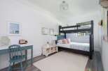This charming bedroom features a space-saving bunk bed, perfect for families or guests.