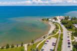 Discover waterfront living with this stunning aerial view of a serene beach and crystal-clear blue waters.