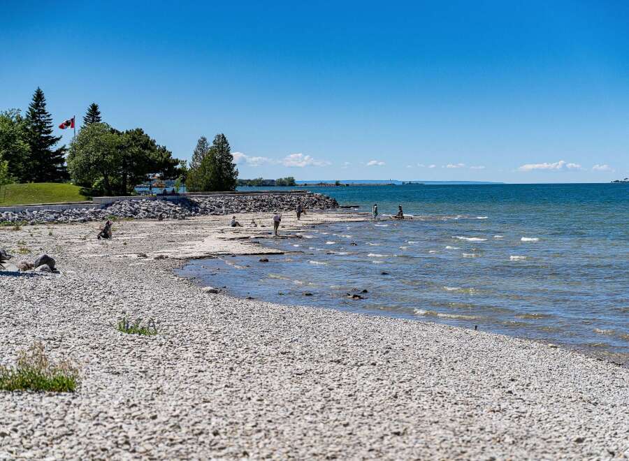 Discover this stunning waterfront property offering direct access to a serene pebble beach and crystal-clear waters.