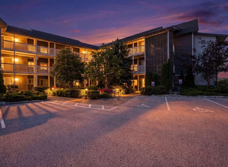 Experience comfortable living in this well-maintained apartment building, beautifully lit at dusk.