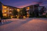 Experience comfortable living in this well-maintained apartment building, beautifully lit at dusk.