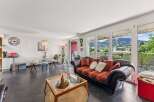Experience breathtaking mountain views from this stunning living area, featuring a comfortable sofa with vibrant patterned cushions and a chic glass coffee table.