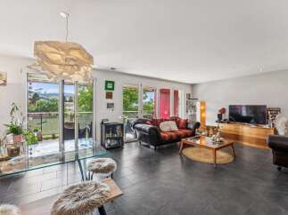 Experience modern living in this spacious open-concept living and dining area, featuring a sleek glass dining table and comfortable seating.