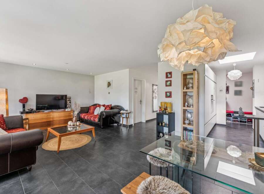 Discover this spacious living area featuring a comfortable leather sofa and a vibrant patterned sofa, perfect for relaxation and entertaining.