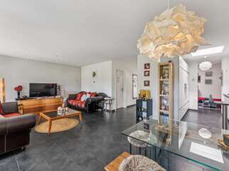 Discover this spacious living area featuring a comfortable leather sofa and a vibrant patterned sofa, perfect for relaxation and entertaining.