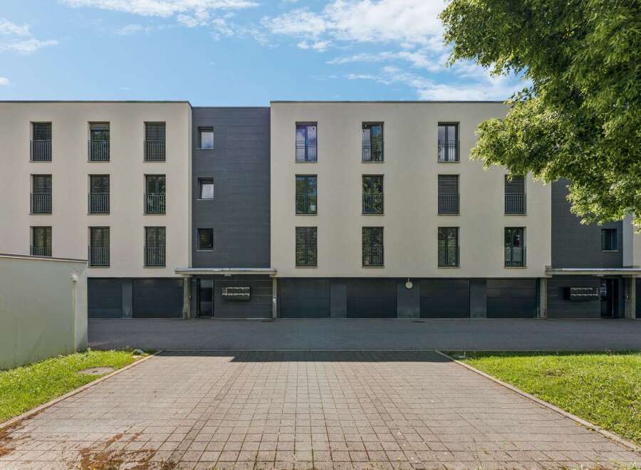 Discover modern living in this contemporary apartment building featuring a sleek facade with contrasting light and dark tones.