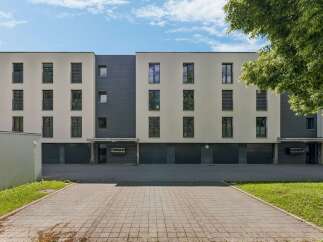 Discover modern living in this contemporary apartment building featuring a sleek facade with contrasting light and dark tones.