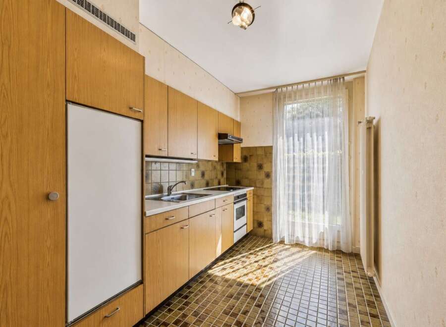 This charming kitchen features warm wooden cabinetry and a practical layout, perfect for everyday use.