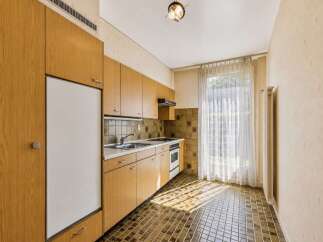 This charming kitchen features warm wooden cabinetry and a practical layout, perfect for everyday use.