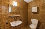 Step into this uniquely designed bathroom featuring warm, golden-brown mosaic tiles that create a cozy and inviting atmosphere.